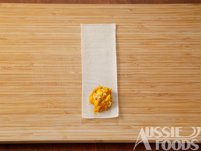 縦に三等分に切った春巻きの手前側に塩こしょうで味つけし、クリームチーズを加え混ぜたかぼちゃをのせる